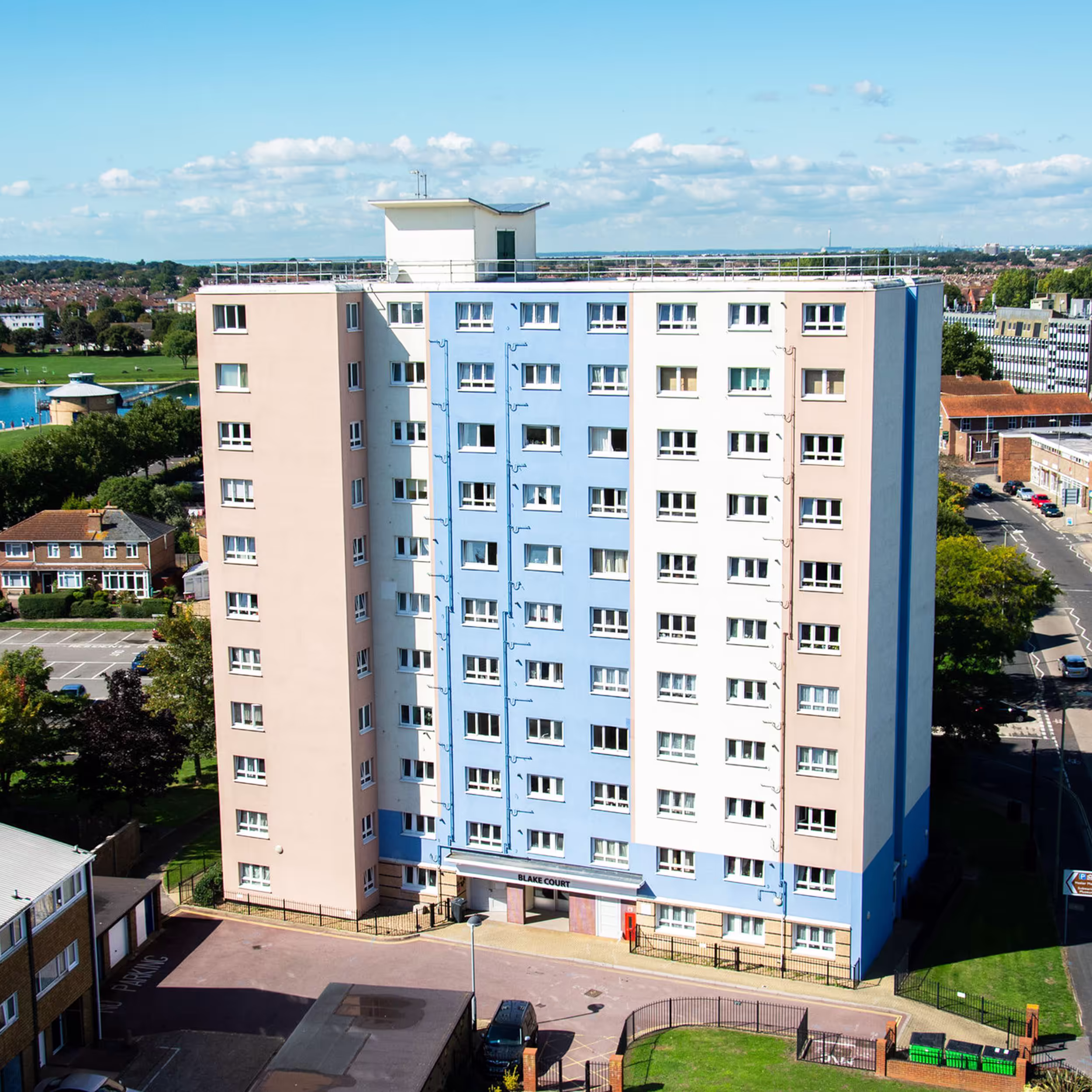 An aerial view of Blake's Court, one of the Gosport Towers, showing the completed new facade with a blue, beige and white colour scheme after cladding replacement.