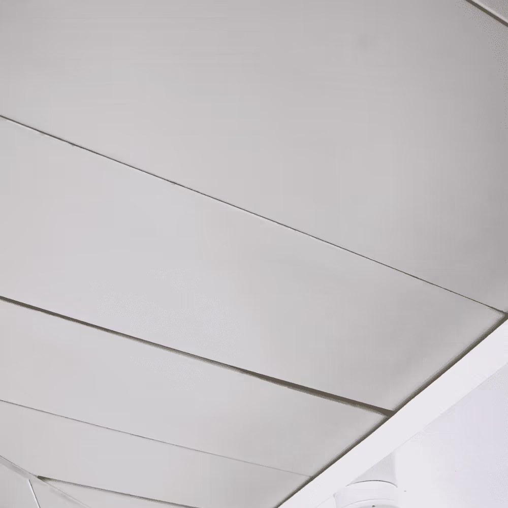 A close-up detail of a newly installed suspended ceiling in a communal area, showing the clean, modern white panels.