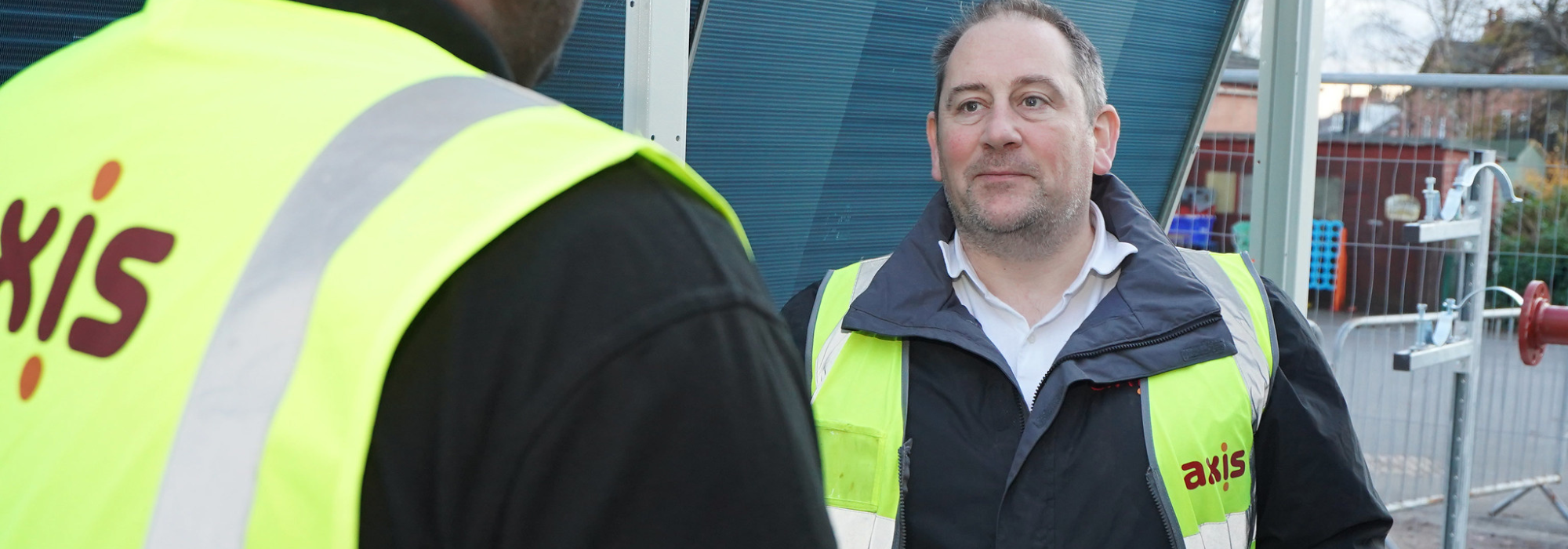 Two men wearing Axis high vis jackets on site